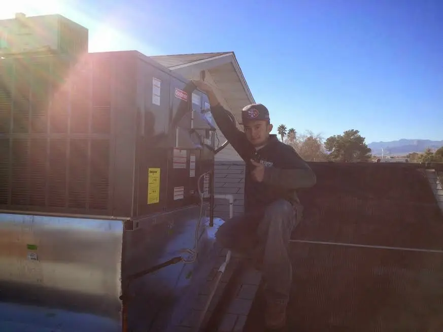 HVAC technician performing AC Tune-Up on a rooftop unit in North Royalton